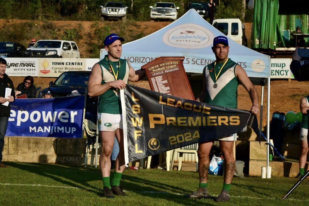 David Cowan and Mat Michael proudly hold the 2024 LSWFL Manjimup Tyrepower League premiership flag after Boyup Brook's Grand Final victory.