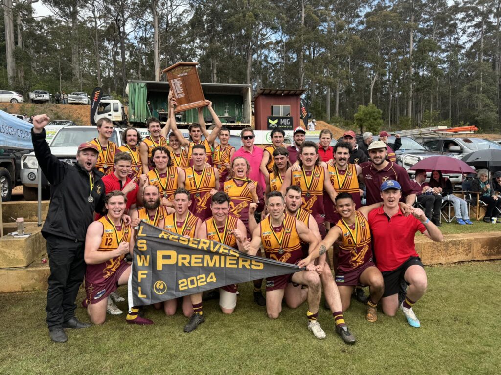 Deanmill Football Club players celebrate their 2024 LSWFL Retravision Manjimup Reserves Grand Final victory, lifting the premiership shield.