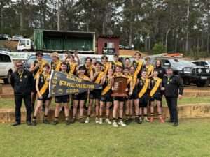 Manjimup Tigers players celebrate their 2024 LSWFL East Perth Football Club Colts Grand Final victory, lifting the premiership shield and flag.